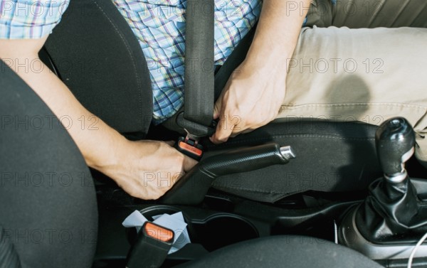 Close up of driver hands fastening the seat belt, Driver's hands putting on the seat belt. Safety