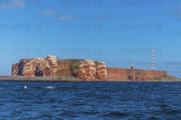 Red red sandstone cliff edge, Heligoland high sea island, North Sea, lighthouse, radio tower, blue