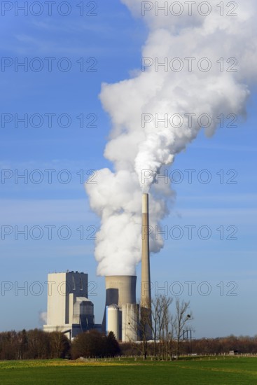Large industrial plant with smoking chimney under a blue sky, coal-fired power plant, coal-fired