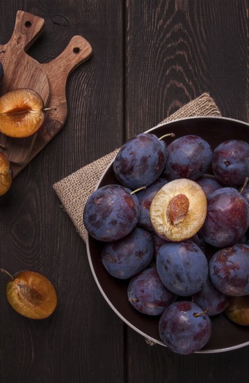 Blue plum, on a wooden table, top view, close-up, no people
