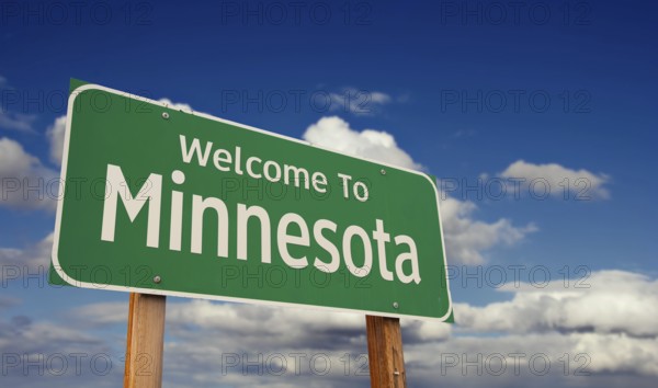 Welcome to minnesota green road sign over blue sky with some clouds