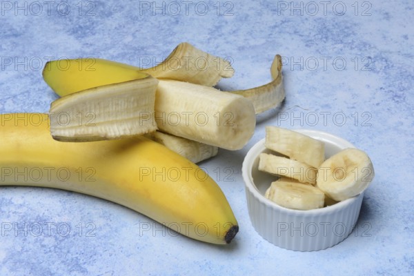 Opened banana and banana slices in peel