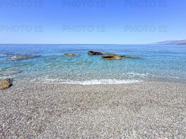 Fine pebble beach with small pebbles stones behind turquoise blue sea sea water calm sea bathing