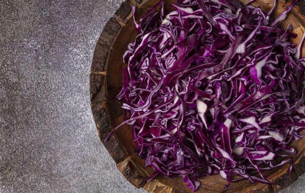Red cabbage, sliced, in a wooden salad bowl, top view, no people