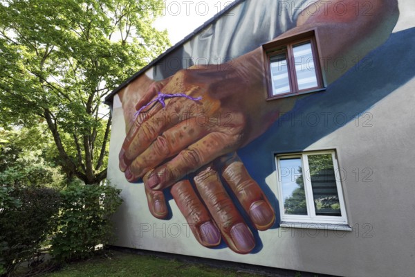 Hands of an old person with a purple Alzheimer's ribbon, mural by street artist Case Maclaim, 40