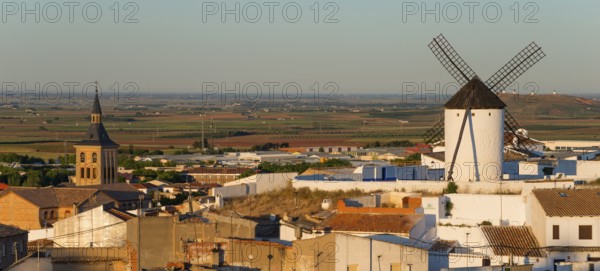 View of a windmill and a village with a church in the morning light, Campo de Criptana, Ciudad Real
