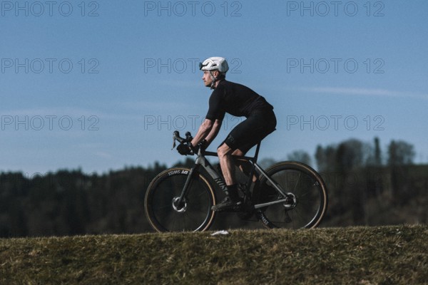 Road bike rider in spring near Halblech in the Allgäu in front of a picturesque backdrop of the