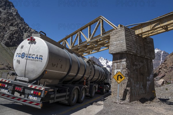 Truck driving under a bridge, mountain pass Los Caracoles, The Snails, road connecting Chile and