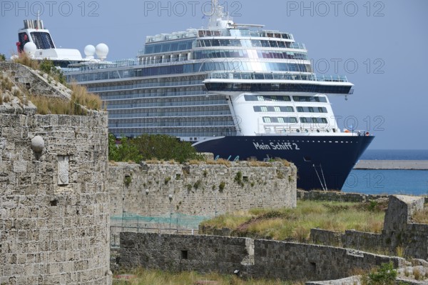 Large cruise ship near an old city wall on a sunny day, TUI, Mein Schiff 2, harbour area, Rhodes