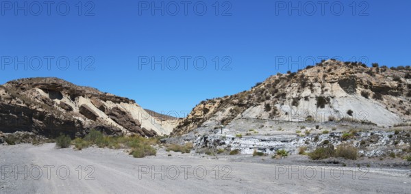 A barren desert landscape with rocky hills and a clear blue sky, La Tortuga, Tabernas Desert,