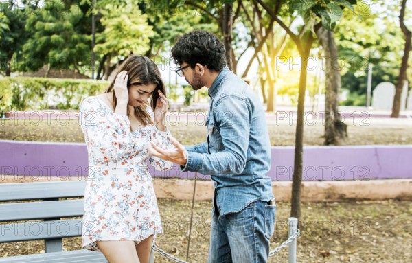Man and woman arguing in a park. Young couple arguing misunderstanding in a park, Unhappy couple