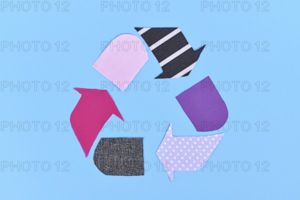 Textile recycling arrow symbol made from old clothing pieces