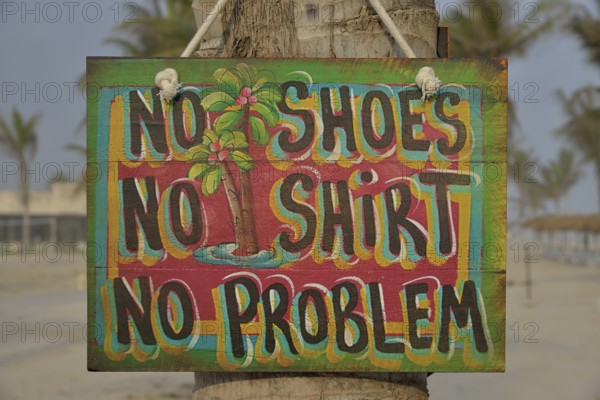 Sign "No shoes, no shirt, no problem" on the beach of Salalah Rotana Resort, Salalah, Dhofar