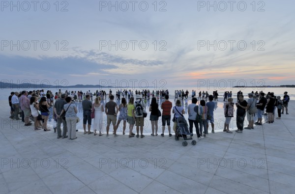 People at the Monument to the Sun, Pozdrav Suncu, by architect Nikole Bašica, at dusk, Zadar,
