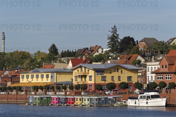 Boathouses on the banks of the Havel River in front of a hotel in the Hanseatic town of Havelberg