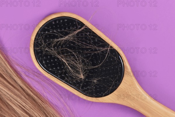 Concept for losing hair with strands of blond hair caught in hair brush