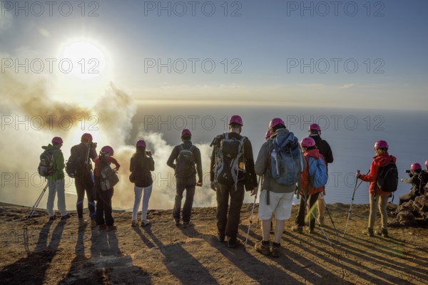 Tourists at the crater edge of the smoking layer volcano Stromboli, island Stromboli, Liparian