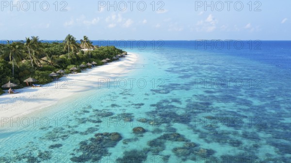 Aerial view bird's eye view of left long beach palm beach of Maldives island, in the middle lagoon