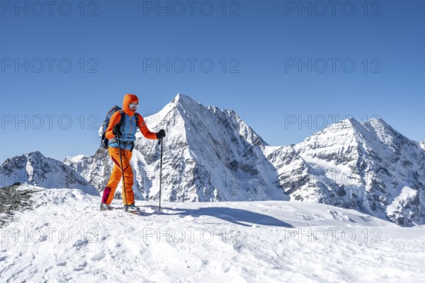 Ski tourers on foot, snow-covered mountain landscape in winter, view of mountain peaks