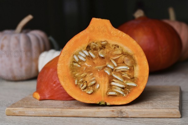 Halved Hokkaido pumpkin showing seed on cutting board in kitchen