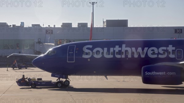 Oakland, California, A worker pushes a Southwest Airlines plane away from the gate at Oakland