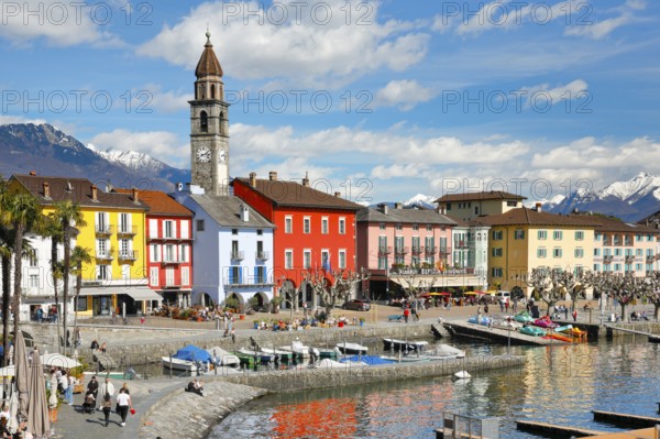 Colourful house facades on the lakeside promenade of Ascona on Lake Maggiore, with snow-capped