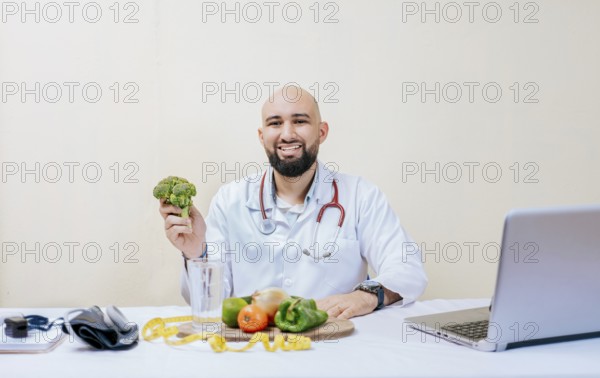 Portrait of smiling nutritionist holding a broccoli. Smiling nutritionist doctor at his desk