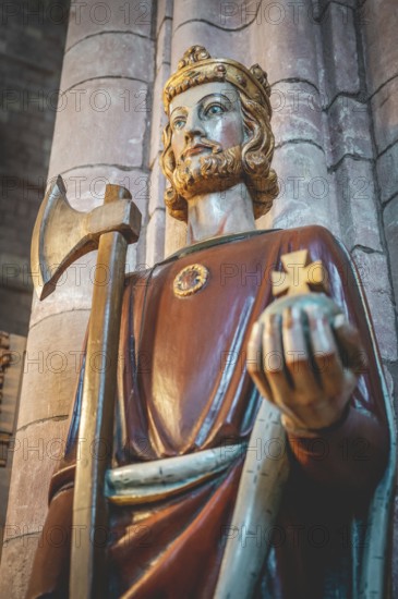 Close-up King holding rich apple, axe and a cross, indoors at St Magnus Cathedral, low angle view,
