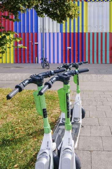 E-scooter in front of the colourful façade of the Mira shopping centre on the Nordhaide in Munich