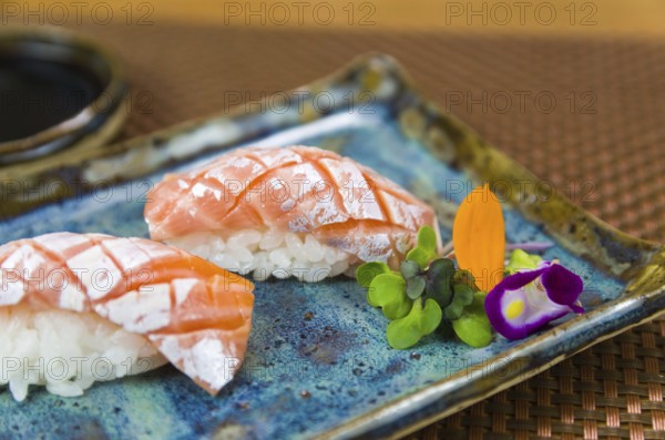 Plate with two elegant nigiri sushi (nigirizushi) with diamond-shaped knife cuts