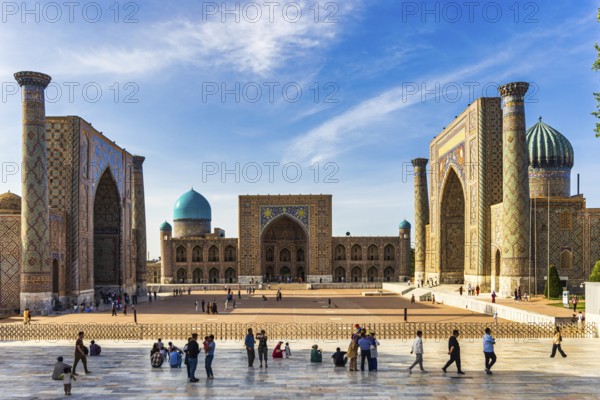Registan square with three madrasahs and tourists on the observation platform
