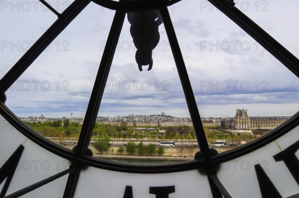 Paris cityscape, skyline view through the famous clock in the Orsay Museum. France. April 2019