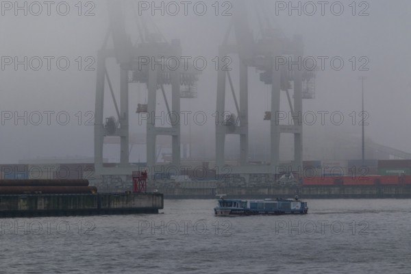 Weather, heavy fog in winter, barge on the Elbe and container gantry cranes in dense fog at the