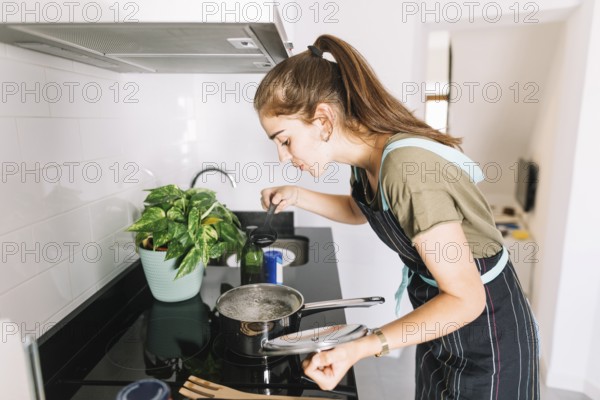 Young woman tasting soup kitchen