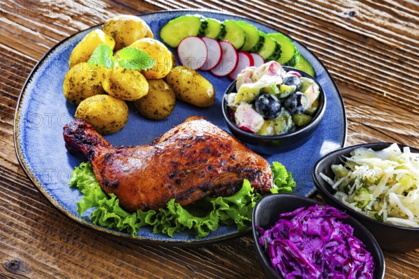 Baked chicken leg with potatoes and vegetable salads