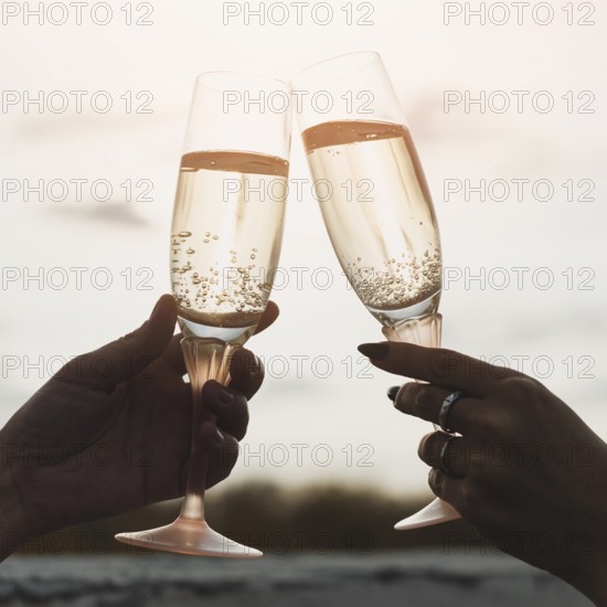 Women holding champagne glasses background sunset