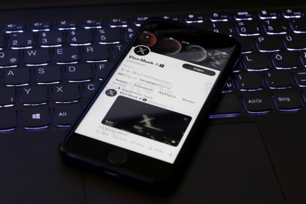 Symbolic image social media, close-up of a smartphone on illuminated computer keyboard with X logo