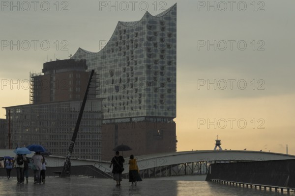 Symbolic picture weather, heavy rain in summer, thunderstorm, storm, tourists with umbrella in the