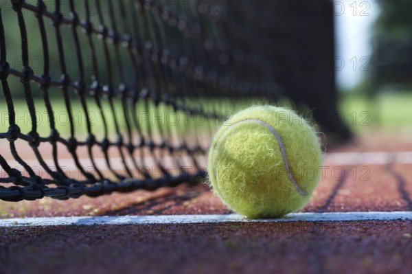 Tennis ball in the net. Ball hitting the tennis net, tennis scene with black net and yellow ball