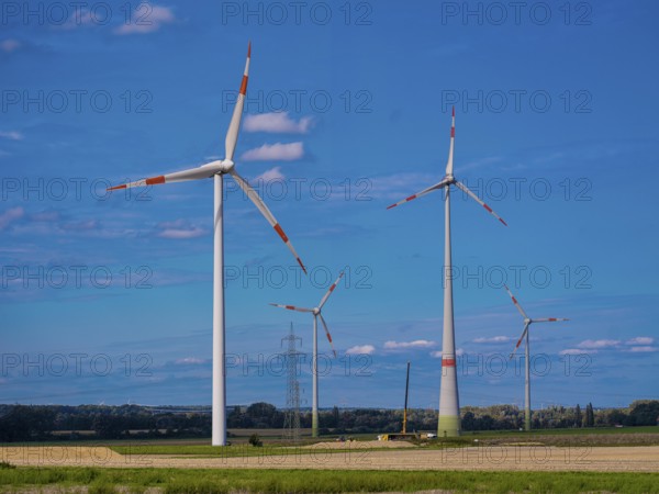Wind turbines and high-voltage pylons with power lines at the Schacht Konrad wind farm, Salzgitter,