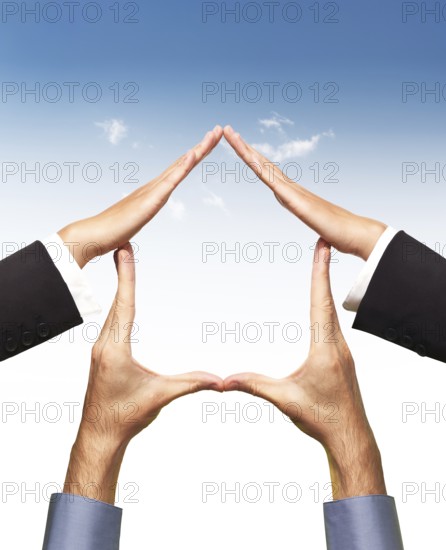 Conceptual home symbol made by hands in a shape of a house over blue sky and white background. Real