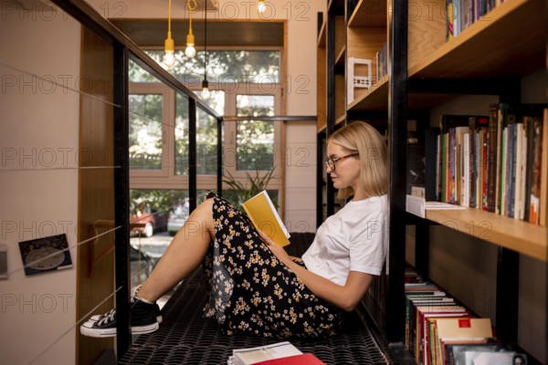 Student reading book library