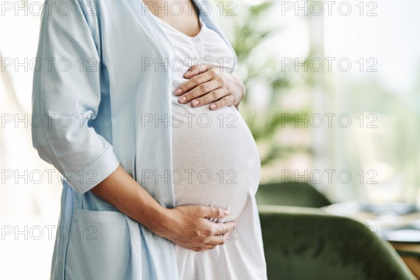 Closeup of pregnant woman holding her belly. Baby expecting, motherhood care, pregnancy and safety