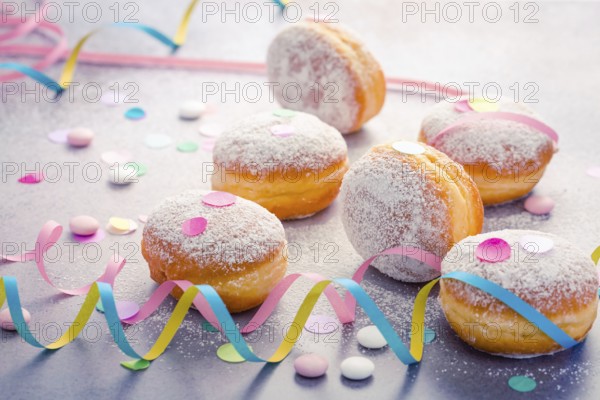 Traditional Berliner for carnival and party. German Krapfen or donuts with streamers and confetti.