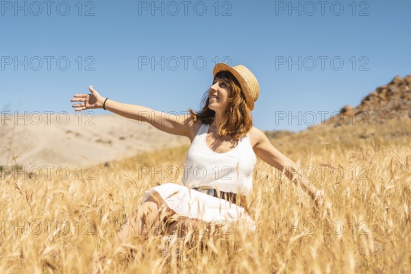 Happy woman enjoying the breeze inside a wheat field in Cabo de Gata, Spain, Europe