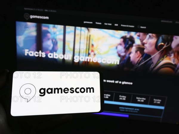 Stuttgart, Germany, 07-15-2023: Person holding smartphone with logo of German video game trade fair