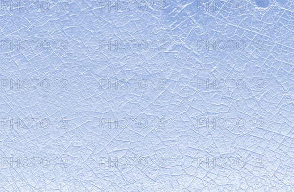 Close-up view of a cracked ice surface with a blue and white color palette, evoking a sense of cold