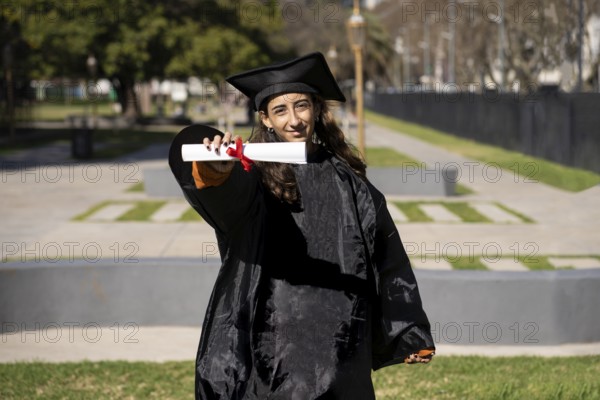 Woman recent graduated, dressed in cap and gown, showing off his degree celebrating