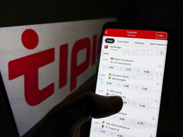 Stuttgart, Germany, 01-08-2022: Person holding smartphone with website of sports betting company