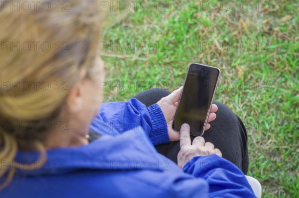 Close up of a woman's wrinkled finger, touching on a cell phone